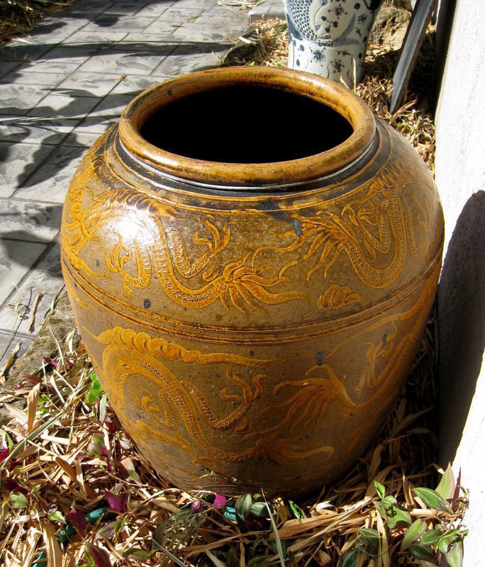 DESCRIPTION: A large, brown-glazed earthenware storage jar with raised and incised slip decorations in yellow ochre of confronting dragons chasing the flaming pearl.  Originating from the coastal area of East China (Zhejiang Province), these jars would have been used to store a variety of items and were shipped from port to port throughout Asia.  Today they make beautiful garden or terrace accents. Excellent condition with no cracks, and dating from about 1930, Republic era.  DIMENSIONS: Measuring an impressive 24” diameter (61 cm) by 28” high (71 cm).  Shipping to be arranged through Craters and Freighters.  <div id='rater_target1049548'></div>

