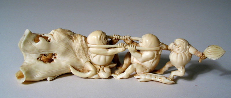 DESCRIPTION:  A charming ivory carving of three pumpkin-shaped imps having a tug-of-war over a pumpkin blossom.  Two imps hold tightly onto a rope while tugging against each other; a smaller imp holds a fan in his left hand while bracing another imp with his right.  This carving has so much excellent detail such as the holes in the blossom, two whisks, wonderful facial expressions and a detailed carved bottom with signature.  No losses, no repairs and dating to the 19th C. Meiji Period.  DIMENSIONS: 7” long (17.6 cm) x 1 5/8” high (4 cm).<div id='rater_target1119909'></div>
