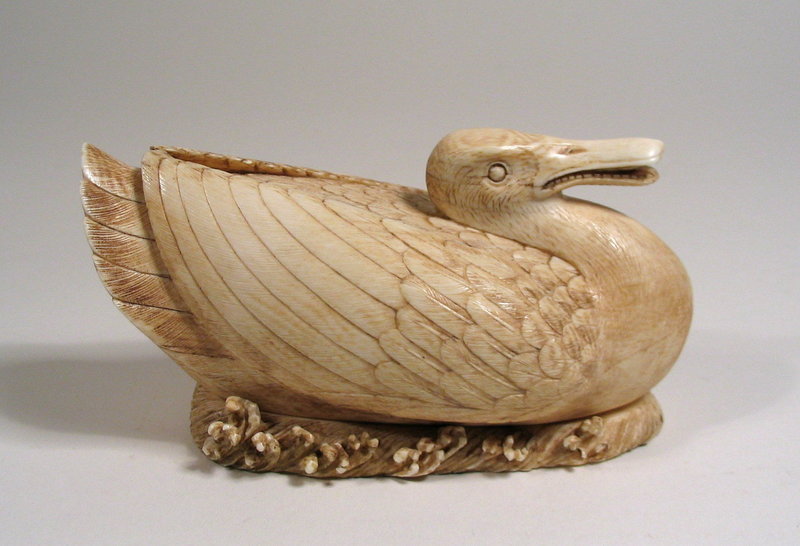 DESCRIPTION:  A realistic and beautifully carved Chinese ivory box in the form of a duck on the waves.  Each feather is delineated and the fitted base is surrounded with small breaking waves.  The inside of the duck is well hollowed.  Very good condition, no losses noted; dating to the early 20th C.  DIMENSIONS: 5” long (12.7 cm) x 2 5/8” high (6.7 cm). <div id='rater_target1135521'></div>
