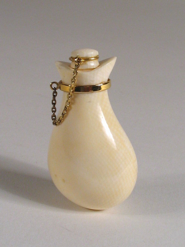 DESCRIPTION: A Chinese ivory bottle, carved in the form of a money bag with 14K gold band and chain which attaches to the bottle stopper.  With its rounded bottom, this bottle was meant to be either attached or suspended by the gold hook attached to the band.  The gold has been tested but is not marked.  Excellent condition.  DIMENSIONS:  2” high (5 cm).<div id='rater_target1150751'></div>
