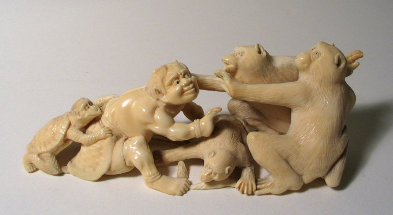 DESCRIPTION:  A delightful and well carved Japanese ivory okimono of a mischievous  oni in a confrontation with two large monkeys.  Crouching at the oni's back is a kappa, another mischievous mythical animal from Japanese folklore.  Here he assists the oni from a safe distance.  A smaller monkey crouches between the opposing figures.  Skillfully carved, including the underside.  Meiji Period (1868 - 1912); very good condition.  DIMENSIONS:   5 1/2" long (14 cm) x 2" high (5 cm).  IVR40 <div id='rater_target1230674'></div>
