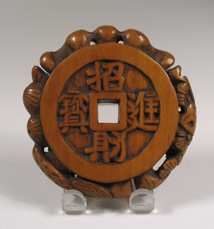DESCRIPTION:  A fine, large Chinese boxwood toggle in the shape of a Chinese coin with four script characters on each side surrounding the square hole.  Around the edge, various plant and animal forms are carved in high relief, including a flower, bird, squirrel and bat.  The suspension cord, connecting it to an object such as a tobacco pouch, would have been strung through the openings under the bat's wings.  Wonderful patina, excellent condition, and dating from the 1800's or earlier.  DIMENSIONS:   2 3/8" diameter (6 cm).  <div id='rater_target1242222'></div>
