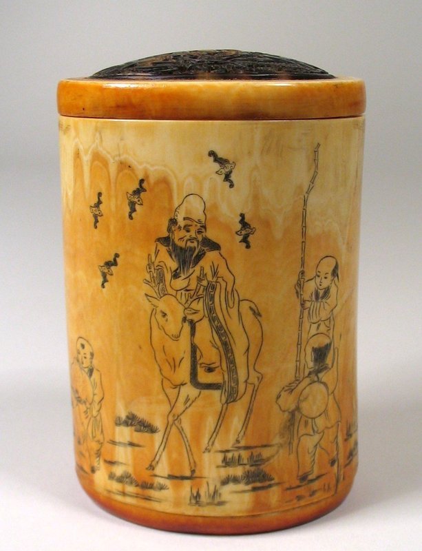 DESCRIPTION:  An antique Chinese ivory cricket box, finely etched with the image of the god of longevity, Shou Lao (or Shou-xing), shown riding his stag with five lucky bats flying overhead.  The stag and the bat both indicate “fu,” or happiness.  Attending him are three boys, one holding the peach of longevity and two holding his gnarled staff.  On the reverse is an etched five line poem that includes signifying marks.  The lid is made from carved and pierced tortoise shell in a design of double dragons chasing a pearl.  This handsome piece has an attractive, aged patina and is in excellent condition.  DIMENSIONS:   3 5/8" high (9.3 cm) x 2 1/2" diameter (6.4 cm).  <div id='rater_target1243510'></div>
