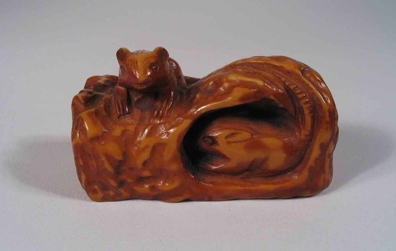 DESCRIPTION:  A stained ivory toggle of three mice climbing on (and nibbling their way into) a loaf of bread.  Chinese toggles (Guajian) acted as counter weights to hang objects from the belt or sash.  Toggles were attached by a cord to personal items such as tobacco pouches, pipes, eating sets, money or other items, and this one was threaded through the two holes on the underside base.  Good condition and dates from the late Qing to Republic Period.  DIMENSIONS: 2” long (5 cm) x 1 ¼” high (3.2 cm).<div id='rater_target1263813'></div>
