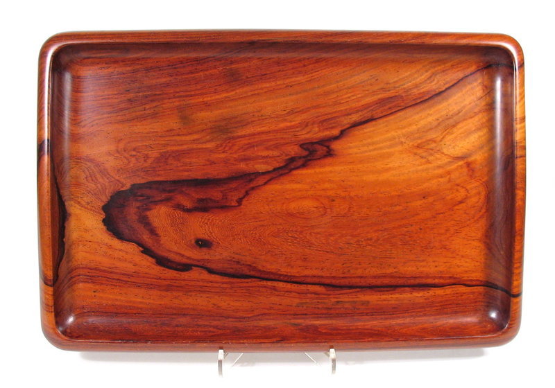 DESCRIPTION:  An extraordinary Chinese tray, its rectangular form crafted from one slab of huanghuali wood that has been skillfully hollowed to expose the beautiful grain and form the graceful, curved edges.   This elegant tray highlights the incredible beauty of this favored Chinese wood and virtually shimmers in the light.  Excellent condition with a nice weight to it; from a private collection.  DIMENSIONS:  13 1/2" wide (34.2 cm) x 9" deep (22.8 cm). <div id='rater_target1264695'></div>
