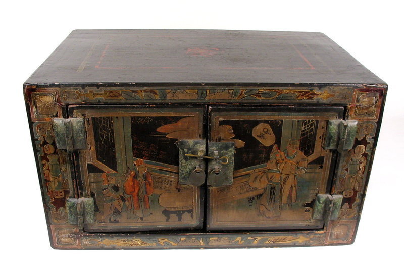DESCRIPTION:  A small black lacquer Chinese cabinet, the front doors with male and female figures in a courtyard setting gazing onto a lake beyond.  The doors are surrounded by a border of  pomegranate leaves and fruit with a vase on either side.  The top, back and sides are lacquered black with faint floral decorations.  Originating from Shanxi Province, this box is in "all original" condition with no repairs or replacements, including the original metal door fittings.  CONDITION:  Has light wear and metal corrosion consistent with its age, which we estimate to be the 1700's, if not earlier.  DIMENSIONS: 18 1/2" wide (47 cm) x 10 5/8" high (27 cm) x 11 1/2" deep (29.2 cm). <div id='rater_target1264791'></div>
