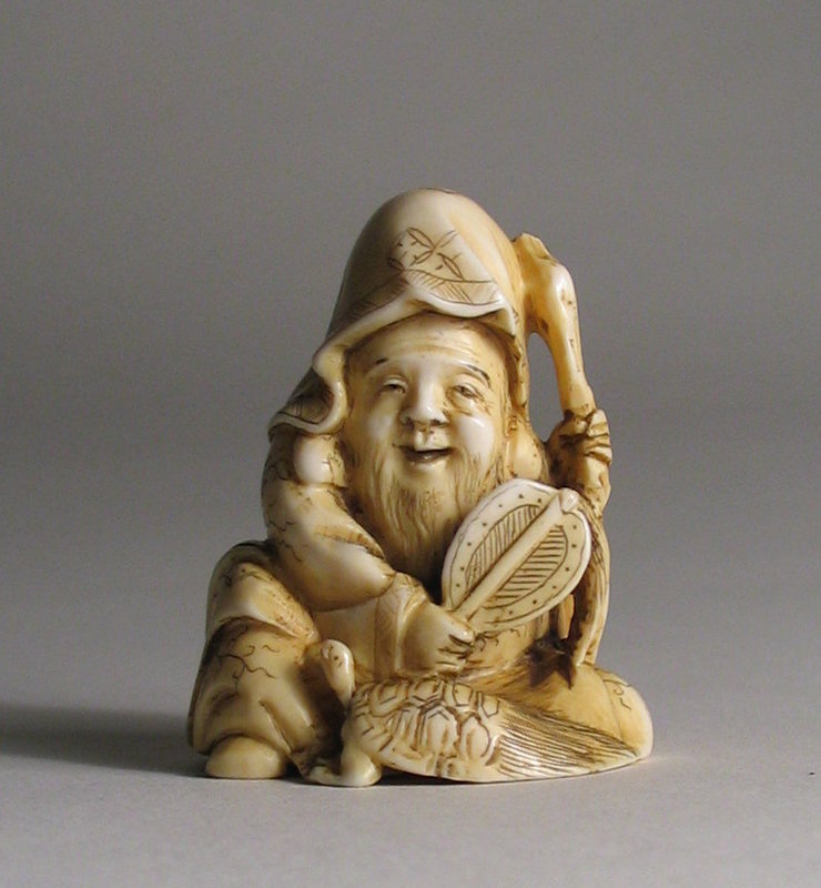DESCRIPTION: A well carved and quite appealing ivory netsuke of Fukurokuju holding a fan in one hand and his staff in the other. Immediately recognizable by his tall, domed forehead, Fukurokuju is the Japanese deity of happiness, prosperity, longevity, and wisdom. Here he is depicted seated with a hairy tailed turtle (minogame) at his feet, also a symbol of longevity which is purported to live 10,000 years. Most likely dating from the late Meiji period (c. 1900), it is in excellent condition and quite well carved with charming expression. DIMENSIONS: 1 ½” high (4 cm) x 1 ¼” wide (3.2 cm).   
<p>NOTE:  Ancient East specializes in pre-1945 Asian art and antiques (generally corresponding to the end of WWII, the Republic of China period, and Japan's Showa Period). Carved works of art are composed of various materials, some including elephant ivory or other endangered species.  We support the goal of eliminating the on-going criminal poaching of endangered animals.  Because we support conservation efforts of live populations, we only feature works of art crafted from these species that are genuine antiques.  However, we believe these antique works of art should also be preserved and have much to offer on behalf of artistic, historical and cultural appreciation.  We also believe the legal sale, collecting and exchanging of these antique items presents no danger to current populations.  Prospective purchasers are advised that a number of states and countries prohibit the importation of property containing endangered species products. We at Ancient East follow all current laws relevant to their sale, import and export. 
<div id='rater_target1289247'></div>
