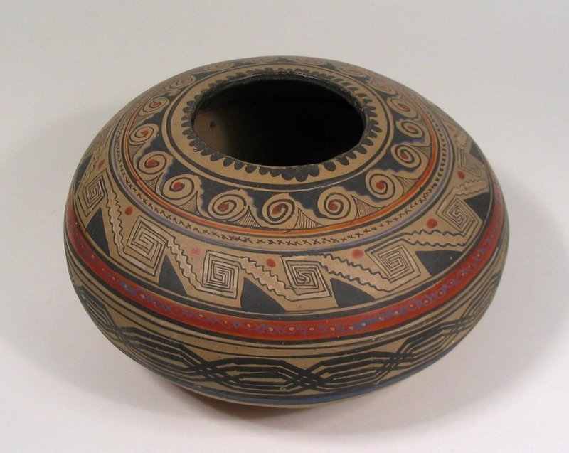 DESCRIPTION:  An intricately painted Native American pottery seed pot or bowl, dating from the early to mid 20th C. (1930 - 1950). This ovoid pot is painted in concentric circular bands of geometric designs separated by red stripes on a taupe colored ground.  On the bottom is written "#22 Vase Navajo Ariz," along with other collectors' identification marks and numbering systems.  Very good condition, minor scuffs and pockmarks; no chips, cracks or restorations. DIMENSIONS:  5" high (12.7 cm) x 9 1/2" diameter (24 cm). <div id='rater_target1290163'></div>
