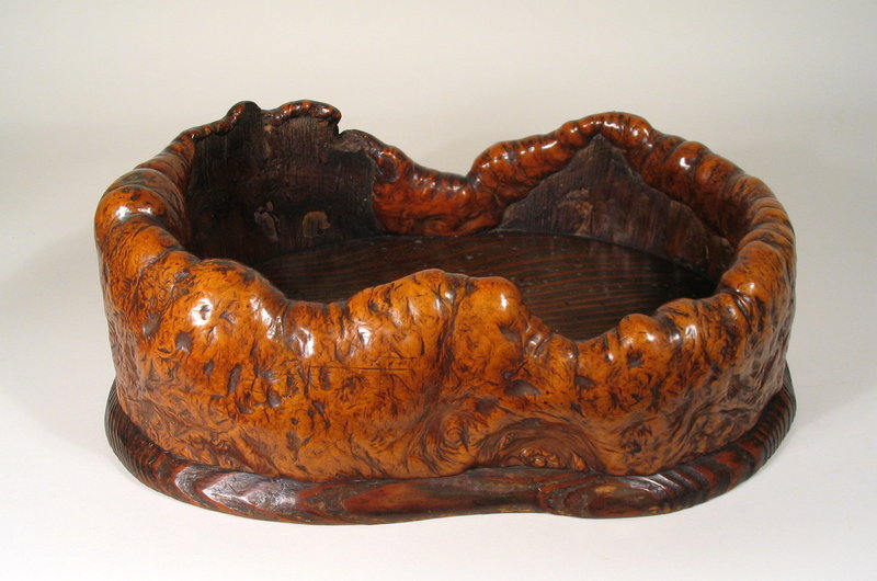 DESCRIPTION:  This large, gorgeous Japanese tray is crafted from a beautifully undulating piece of burl with curled edges that turn and overlap into the interior. The wood is a rich brown and twists in the most sumptuous patterns; the base is made from one flat slab of Kiri (Paulownia) wood. Striking and unique from any angle, it is a testament to the eye of the craftsman who saw its beauty and fashioned it for use.  Excellent condition and dating from the Meiji period (1868 – 1912).  DIMENSIONS: 15 ¼” long (38.6 cm) x 12” wide (30.5 cm) x 5 ½” high (14 cm).  <div id='rater_target1305697'></div>
