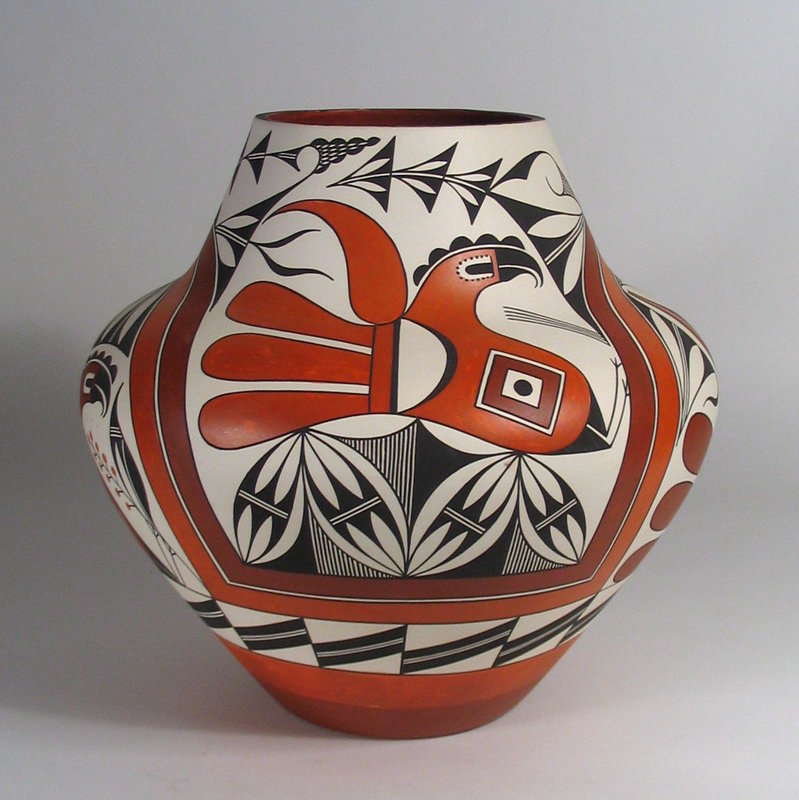 DESCRIPTION:  A quite spectacular Acoma pot of great size and shape with a wonderfully complex design by Acoma artist, Adrian Vallo.  A double rainbow of light and dark sienna bands divides this beautiful greenware olla into four quadrants, with two lively dark-sienna parrots below the arched rainbows, and two lighter sienna parrots above horizontal rainbow bands.  Additional geometric designs in black on white are executed with clean, crisp lines.  Very good condition, minor surface scratches, and one tiny interior rim chip. Signed on the bottom, "A. Vallo, Acoma, 1999."  DIMENSIONS:  A large 13.5" high x 14" diameter.


<p>ABOUT THE ARTIST: Adrian Vallo was born into the Acoma Pueblo in 1964 and began his interest in pottery making when he was 20 years old.  His grandmother, the late Santana Cerno,  taught Adrian to coil, shape, paint, and fire pottery.  An artist of superior technical proficiency, he often paints traditional designs and motifs, such as Acoma parrots or deer patterns.  He gathers natural pigments from the Acoma Pueblo to paint his pottery and cleans, mixes, hand coils, shapes, paints, and fires his pottery the traditional way, outdoors.  He has won awards at both the New Mexico State Fair and the Arizona Casa Grande, and is featured in "Southern Pueblo Pottery 2,000 Artist Biographies." 
<div id='rater_target1305814'></div>
