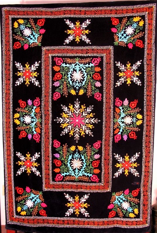 DESCRIPTION: A vibrant Suzani coverlet, finely embroidered with colorful silk threads on a black velvet ground.  Suzani (meaning “needlework”) is a type of embroidered tribal textile made in Uzbekistan, Kazakhstan and other Central Asian countries.  These coverlets are traditionally made by Central Asian brides for their dowry and presented to the groom on the wedding day.

<p>This suzani was acquired in Turkey from an Uzbek family and displays traditional design motifs such as sun and moon disks, flowers, leaves, vines and pomegranates.  CONDITION:  Mostly excellent; one 2” tear at the bottom right of center medallion.  DIMENSIONS: 76.5” x 51.5”
<div id='rater_target1363770'></div>
