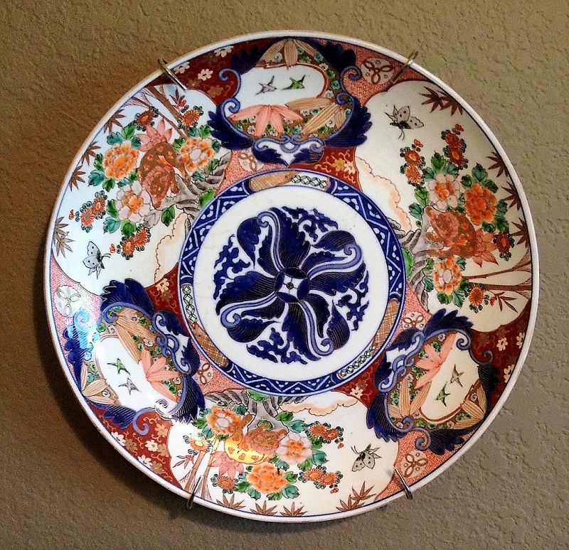 DESCRIPTION:  Outstanding Japanese porcelain Imari charger, circa 1880, acquired in Brussels, Belgium. This charger is profusely painted in under-glazed blue, red, green and gilt with a central blue medallion of scrolls highlighted in gilt. Surrounding the medallion is a wide border of alternating cartouches enclosing pairs of birds with bamboo leaves, and flowers issuing from rockwork with butterfly. The reverse is painted with three sets of flowering blue branches. Perfect condition, no cracks, hairlines or restorations. DIMENSIONS: 15 5/8” diameter (39.6 cm).
<div id='rater_target1366148'></div>
