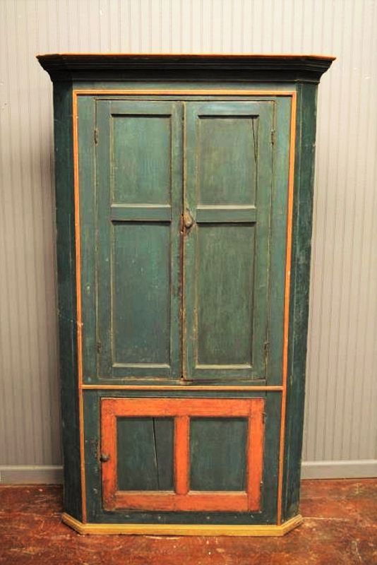 DESCRIPTION:  An early 19th C. three door country New England corner cupboard in original dark blue paint with reddish trim.  The interior is washed with a pale green milk paint and has three shelves in the upper portion and storage space in the bottom.  Two door panels have age cracks to the wood.  A superb piece for a country interior.  DIMENSIONS:  71 1/2" high x 41 1/2" wide x 19 1/2" deep.
<div id='rater_target1372207'></div>
