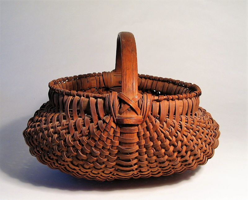 DESCRIPTION: A very good woven oak-splint basket in lobed buttocks form, used as a field gathering basket or a market basket for goods. This large, late 1800’s to early 1900’s Pennsylvania basket has a sturdy bentwood handle with bentwood-wrapped rims. CONDITION: Very good with minor age-appropriate usage wear and losses. DIMENSIONS: 20” wide x 14" high x 16.5” deep.
<div id='rater_target1373001'></div>
