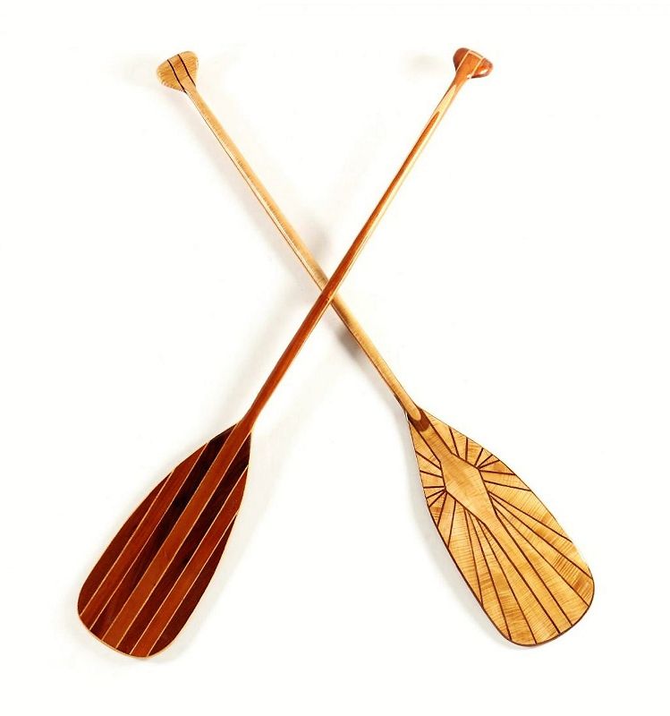 Pair<br /><br />
DESCRIPTION: A pair of beautiful 20th C. handcrafted canoe paddles, skillfully laminated from select high-grade exotic woods including curly maple, rosewood, walnut, satinwood and mahogany, each with geometric inlays.  These paddles are so elegant you'll want to hang them in you lake or river home as décor, although they are perfectly suited for actual use. From the collection of Mr. Wayne Lockey of Grand Junction, Colorado. DIMENSIONS: 60” long each.
<div id='rater_target1374805'></div>
