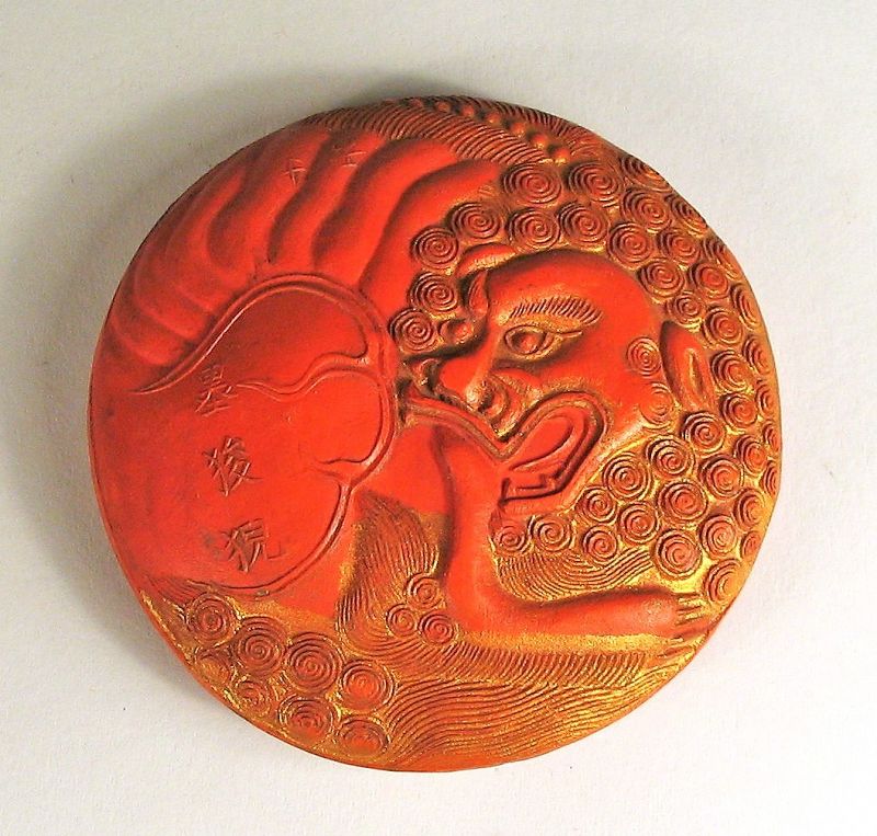 DESCRIPTION: A fine red and gilt Chinese scholar's ink cake in circular form with the front and back molded in relief in the form of a foo dog (shi shi) with tightly curled mane. Both the front and back have raised Chinese characters in relief.  Excellent condition in original box, and dating from the first quarter of the 20th C. or earlier. DIMENSIONS: 2 ¾” diameter (7 cm).   
<div id='rater_target1389294'></div>
