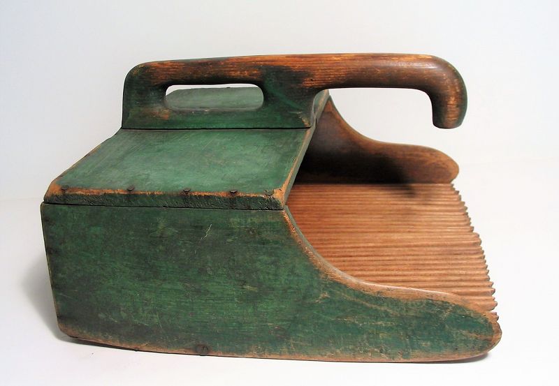 DESCRIPTION:  An appealing antique cranberry scoop in original green paint, constructed in a lovely sculptural form with attached handle and a scoop with multiple slim prongs to strain out water without losing the cranberries.  CONDITION:  Usage wear in all the right places; split to board holding prongs. DIMENSIONS:  13.25” wide x 13.25” long x 7.5” high.
<div id='rater_target1393999'></div>
