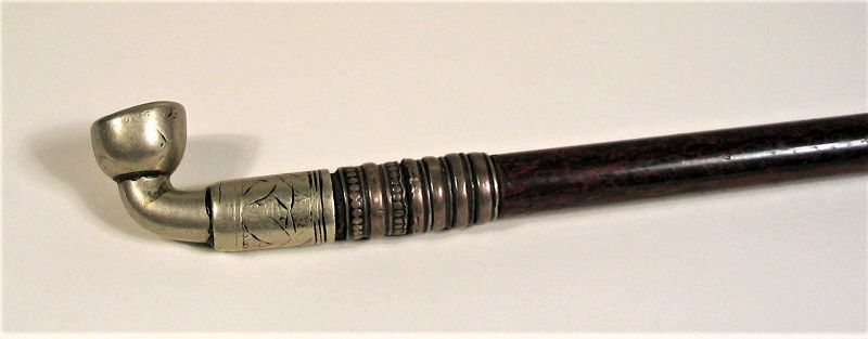 DESCRIPTION: A beautiful antique Chinese tobacco pipe, elegantly crafted from a long bamboo stem lacquered in red and black. The tip (bit) is carved from a pure white nephrite jade stone that is tapered and then flared to form the lip. The bowl and shank are crafted from silver metal, and bands of brass rings decorate each end. This pipe is in excellent condition and dates from the latter Qing Dynasty. DIMENSIONS: 17 ¼” long (44 cm).   
<div id='rater_target1394052'></div>
