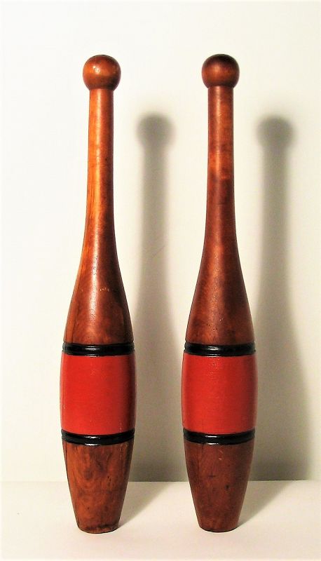 Pair<br /><br />
DESCRIPTION:  A good pair of wooden exercise clubs / juggling pins, each painted with a wide horizontal orange stripe between two thin black stripes.  Good condition with normal wear.  DIMENSIONS:  Each is 18” tall x 3” diameter.
<div id='rater_target1394118'></div>
