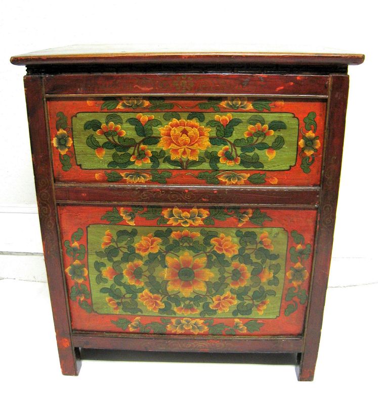 DESCRIPTION:  A colorfully painted Tibetan chest with four side drawers having leather strap pulls (two drawers on each side).  The chest is painted with green floral panels having red floral borders and is supported by short legs.   A carved key fret pattern decorates the neck just below the top.  Dating from the 19th C, this chest is in good condition with very minor scuffs to paint.  DIMENSIONS: 33” high x 28.5” wide x 18”deep.
<div id='rater_target1399598'></div>
