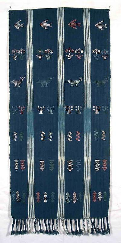 DESCRIPTION: A hand woven textile made from natural cotton with stitched embroidery using all natural dyes.  The four section indigo colored background alternates with three woven white vertical stripes.  On each blue panel, various naturalistic designs have been hand embroidered, such as fish, deer, flowers, running water (the zig zag motif), etc.  The lower edge ends in braided tassels while the upper edge is hemmed.  This textile banner originates from the Patricia Naenna weaving studio, located at the foot of Doi Suthep Mountain in Chiang Mai, Thailand.  Ms. Naenna is an expert in Lao and Thai textiles, and her studio encourages the continuation of traditional weaving techniques by indigenous people. DIMENSIONS:  39” long x 17 ½” wide.<div id='rater_target420711'></div>
