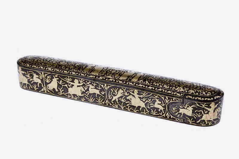 DESCRIPTION:  Inlaid Persian metalwork has long been distinguished for its fine craftsmanship and elaborate designs.  Here we have an early 19th C. iron pen box, exquisitely inlaid with gold on all surfaces.  On the top is featured three cartouches, the two outer ones with birds in a setting of intricate floral decorations, and the center with seated and standing figures on either side of a table.  Elaborate big game hunting scenes surround all sides of the box, featuring men on galloping horses wielding their swords against lions and stags.  Hunting as a royal activity has a long history in the Middle East and its imagery plays a key role in the arts of Iran and India.  
<p>The box slides open to reveal the compartment for holding the pen as well as the original ink pot with hinged lid, also inlaid with gold.  Covering the base is a continuous scrolling vine motif.  Such a pen box would have been a luxury item commission by the wealthy elite or given in recognition of some official accomplishment.  First quarter of the 19th century, very good condition with very little loss of the gold inlay; a few superficial light rust spots on the inner pen compartment.  When closed, the outer cover and inner compartment fit snugly together.  DIMENSIONS:  7 ¾” wide x 1” high x 1 ¼” deep. <div id='rater_target461627'></div>
