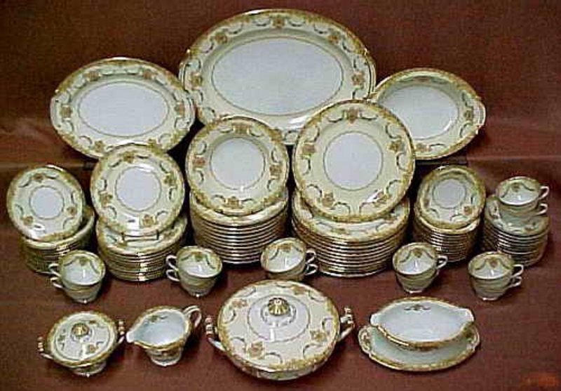 DESCRIPTION:  A very elegant and complete porcelain Noritake dinnerware set for twelve in the Camillia pattern, having intricate hand painted gilt designs with medallions and floral swags against white porcelain.  The set includes twelve dinner plates, luncheon plates, large and small bowls, salad plates, and cups and saucers.  Serving pieces include a creamer, sugar, gravy boat, covered tureen, two vegetable dishes and a platter.  This mid 20th century set is in remarkable, excellent condition with no chips or repairs on any of the pieces. <div id='rater_target490882'></div>
