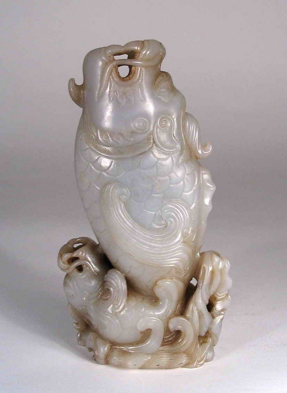 DESCRIPTION: A finely carved Chinese josh stick (incense) holder, crafted from a grey nephrite stone in the form of two fish, one leaping high out of the water and the other smaller fish upside down at the base.  Both fish have open mouths to hold the josh sticks, the residue from which still remaining in the mouths and crevices (we have not cleaned it). The carving detail is excellent, even on the underside, and the condition is perfect.  From a private Philadelphia collection and dating from the latter Qing Dynasty, 19th/20th C.  DIMENSIONS: 6 ¼” high (16 cm) x 3 ½” wide (9 cm). <div id='rater_target830311'></div>
