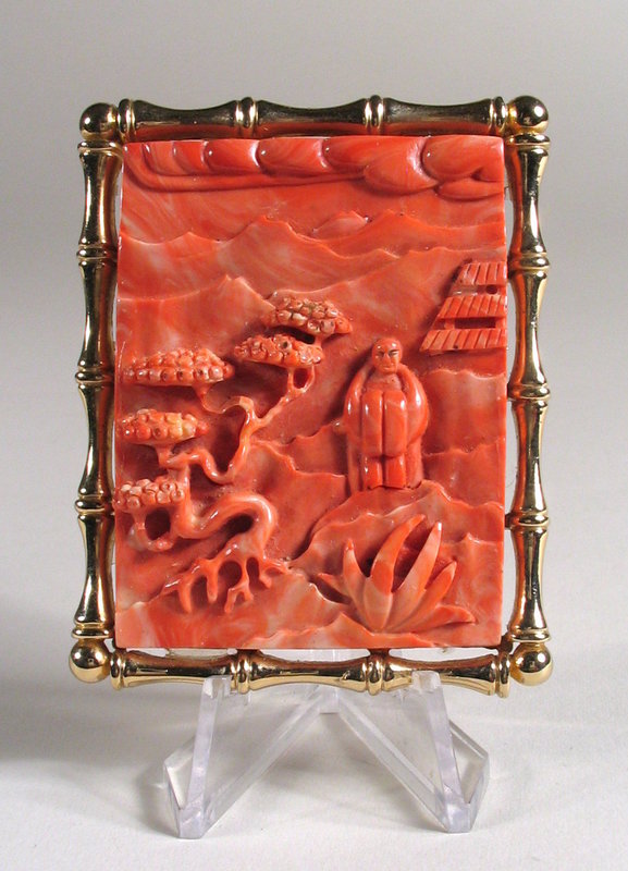 DESCRIPTION: A Chinese pendant with coral colored stone mounted as a brooch in high relief with a scholar standing under a twisting pine in a mountain setting.  The rectangular gilt frame is cast as four bamboo stalks and has a sturdy open “mesh” backing fitted with a stick pin and gold loop so that it can be worn as a brooch or necklace.  Very fine work overall with no tarnish anywhere to the gilt frame.  DIMENSIONS: 2 3/8” long (6 cm) x 1 7/8” wide (4.8 cm).  <div id='rater_target1149763'></div>
