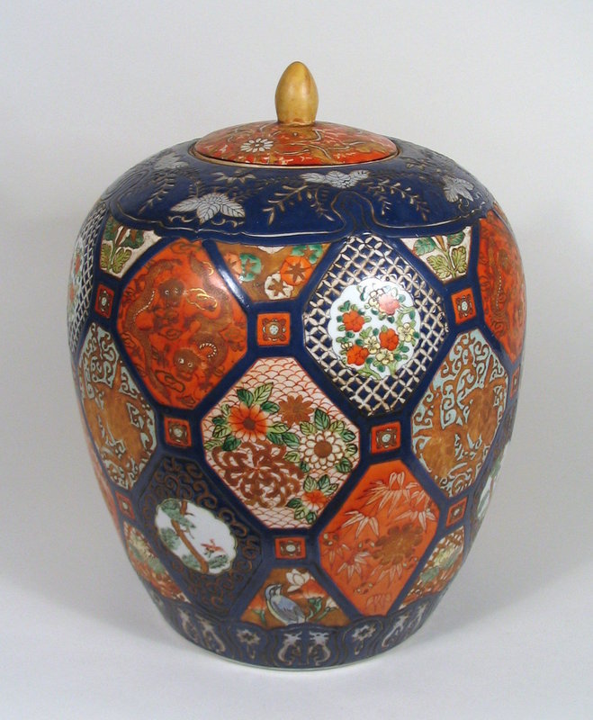 DESCRIPTION: A large and colorful Chinese fencai Imari lidded jar, the body decorated with diamond shaped, hand painted panels in raised enamels with designs of flowers, dragons, bamboo, birds and pine, separated by dark blue borders.  The shoulder and foot are bordered in dark blue with white designs, while the knobbed lid is enameled with white flowers on an orange ground. The base is marked with a "Ya Wan Zhen Cang" red seal, dating it to the mid 20th C.  A very decorative, focal point jar in excellent condition with no chips or cracks.  DIMENSIONS: 13 1/2" H (34.3 cm) x 10" diameter (25.5 cm).<div id='rater_target1194669'></div>
