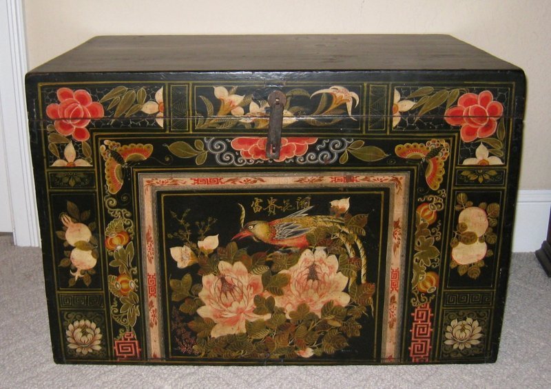 DESCRIPTION: A large Mongolian trunk, the front delightfully hand painted with a large, colorful bird perched upon leafy blooms, around which are fanciful borders of butterflies, pomegranates, lilies and large red blossoms.  Sturdily constructed of light weight Poplar wood, the top and sides are lacquered black while the back is red. A perfect place to store linens and blankets, it would also make an attractive bedside table.  Very good condition and  dating from around 1900 - 1910. DIMENSIONS: 34" wide (86.5 cm) x 21 1/4" deep (54 cm) x 23" high (58.5 cm). <div id='rater_target1197885'></div>
