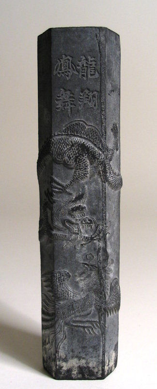 DESCRIPTION:  A long, six-sided Chinese ink stick with nicely detailed dragon and phoenix curling about the surface.  Short, impressed Chinese inscriptions are found on two sides.   One of the four treasures of the scholar's studio, ink sticks (or cakes) would be carefully ground by the scholar and mixed with water on an inkstone to paint calligraphy or scrolls with a brush. This black ink stick is in good antique condition. DIMENSIONS:  6 1/2" long (16.5 cm) x 1 1/4" diameter (3.2 cm). <div id='rater_target1231068'></div>
