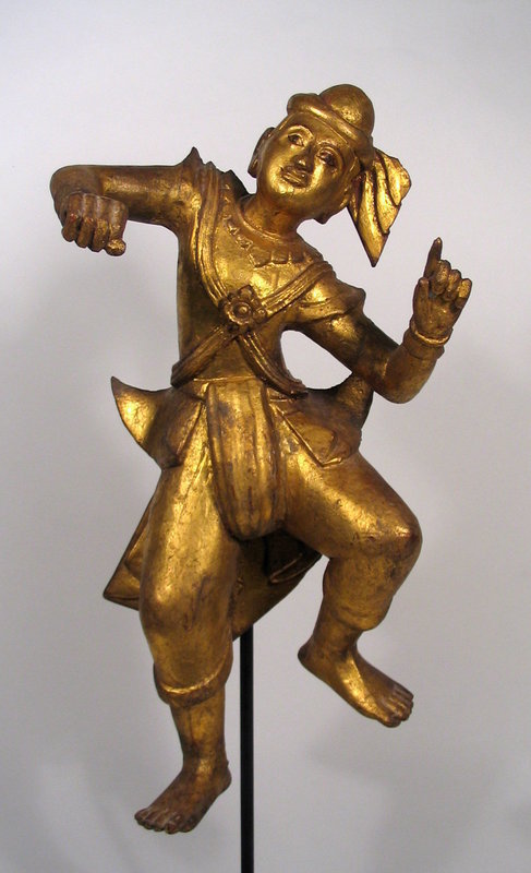 DESCRIPTION:  A large, handsome Burmese wood sculpture of a male Nat, or nature spirit, dressed in traditional attire and engaged in a joyful dance.  Such images were first carved from wood, then laboriously decorated with applications of red lacquer then gold gilt. Dating from the early 20th C., it has been mounted on a rod with square base.  Please see the last photo for size comparison with our other Nat, FIG56.  Although not purchased as a pair, these make wonderful companion pieces.  DIMENSIONS:  26" high with stand (66 cm) x 10" wide (25.5 cm). 
	
<P>CULTURAL BACKGROUND:  Prior to the advent of Buddhism, Burmese were animists who worshipped a series of nature spirits called Nats.  Later these were incorporated into Buddhism and often Nat statues will be found in Buddhist temples. These spirits often have their own ceremonies and festivals and are worshipped in addition to the Buddha. There are 37 officially recognized Nats, each with its own history, legend and image, all having important or heroic roles in Burmese history. The Nats, as spirits of natural forces such as water, wind, stones and trees, can take many guises.  
<div id='rater_target1256810'></div>

