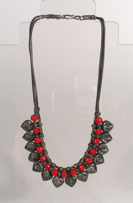 DESCRIPTION: A Chinese Hill Tribe necklace, handmade of alternating coral colored beads and silver repousse lappets, strung on two lengths of woven silver chain with hook clasp. A very attractive short necklace dating from the early to mid 20th Century.  In very good condition and a nice example of ethnographic Chinese tribal jewelry.  DIMENSIONS: 9”  drop when clasped; lappets are 1” long each. <div id='rater_target1268694'></div>

