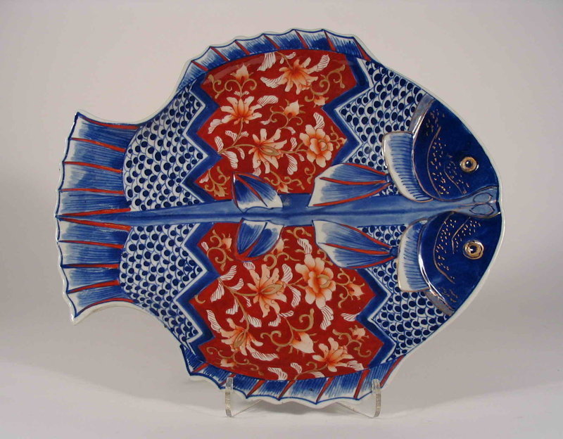DESCRIPTION:  A Japanese Imari porcelain dish, shaped in “double fish” form and decorated in traditional Imari colors with floral designs in rust red, and fish scales and fins in royal blue.  The reverse has painted florals and grasses on the four sides.  Late 19th/early 20th century, and in excellent condition with no chips or restorations.  DIMENSIONS:  10 ½” long (26.6 cm) x 9” wide (23 cm).    <div id='rater_target1276497'></div>

