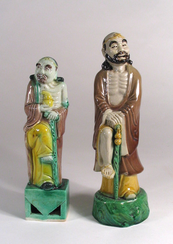 each or $190.00 for the pair<br /><br />
DESCRIPTION:  A pair of porcelain figures, each a representation of Li T'ieh-kuai, one of the Chinese eight immortals.  Li T'ieh-kuai  is always represented as a lame beggar leaning on a crutch with a pilgrim's gourd in hand.  The Eight Immortals are legendary beings of the Taoist sect who attained immortality and dwell in the remote hills and mountains of China.  Both of these figures date from C. 1900, with the larger one's inner base stamped with "China" in red ink.  Both are in perfect condition.   DIMENSIONS:   Smaller figure is 7 3/4" high (19.7 cm); larger figure is 9 1/4" high (23.5 cm).   <div id='rater_target1277981'></div>
