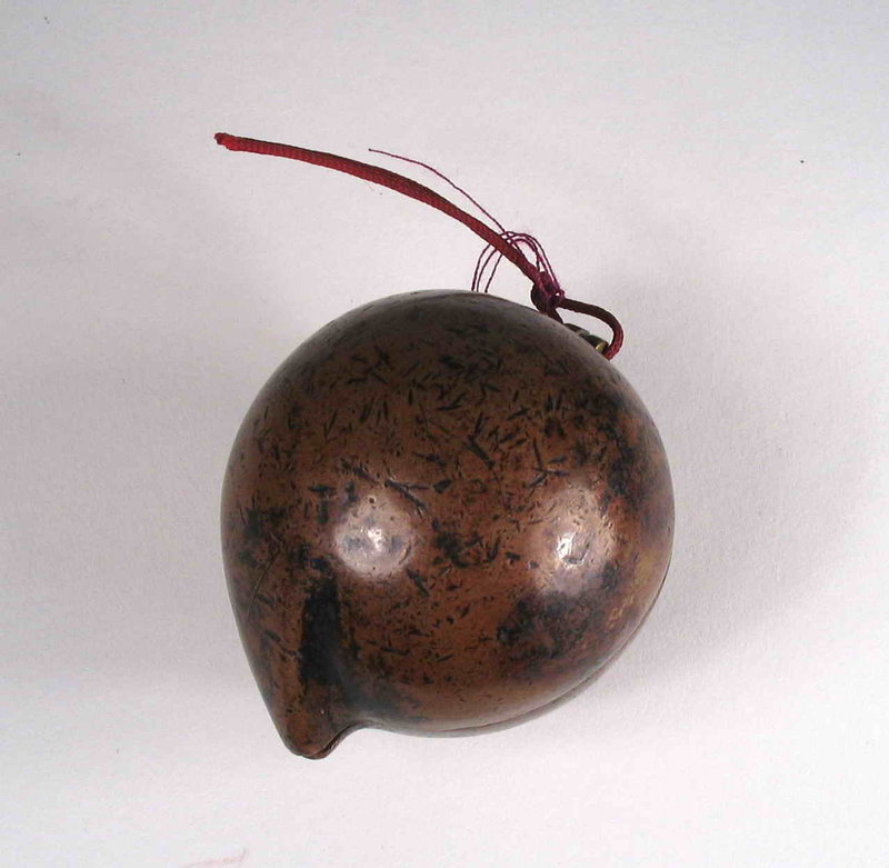 DESCRIPTION: An unusual and quite old (18th C.) copper box toggle in the form of a peach, the Chinese symbol of longevity. Probably used as both a toggle and tobacco container, the two halves have a tightly fitting overlapping seal, with two loops forming the hinge at the stem point. This large solid copper toggle has a rich, aged patina and is in fine condition with minor signs of wear, as to be expected. DIMENSIONS: Approximately 2 1/4” long, tip to tip (5.7 cm) x 1 ¾” diameter (4.5 cm). 
<p>ABOUT CHINESE TOGGLES: Chinese toggles (Guajian) are the precursors of the Japanese netsuke by many centuries, and acted as counter weights to hang objects from the belt or sash. While toggles share similarities with their Japanese counterparts, they set themselves apart since most were fashioned by the user rather than by established artists as was the case in Japan.  Since Chinese robes did not include pockets, toggles were attached by a cord to a waist sash for personal items such as tobacco pouches, pipes, eating sets, money or other items. Usually worn by men, they are most often made of wood, but toggles can also be found in jade, ivory and semiprecious stone. These beautiful folk objects reflected the expression and identity of their creators, and became amulets that were worm, fondled, and cherished for their ability to bestow good fortune, longevity, fertility, happiness and health.  
<div id='rater_target1287370'></div>
