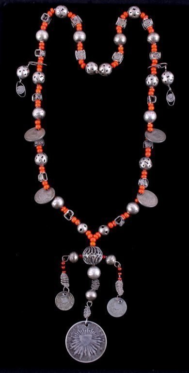 DESCRIPTION: An early Southwestern Native American trade bead necklace with rare orange glass trade beads strung in pairs then separated by hand worked silver beads, some round with alternating pierced beads, and some with twisted silver wire set within square frames.  Also included are a total of six Republica de Guatemala silver coins (two 1/2 Reals and four 1 Reals), all dated between 1900 and 1912, and one large Republica Mexicana 8 Reales with the liberty cap and starburst pattern, dated 1859, P.F. 10D 20G.  This necklace is striking when worn and is a vivid historical reminder of the melding of the Southwest's rich Native American, Spanish Colonial and Mexican territorial history.  DIMENSIONS:  Necklace is 18" long strung (45.8 cm).  Round silver beads are each 5/8" in diameter.  <div id='rater_target1303412'></div>
