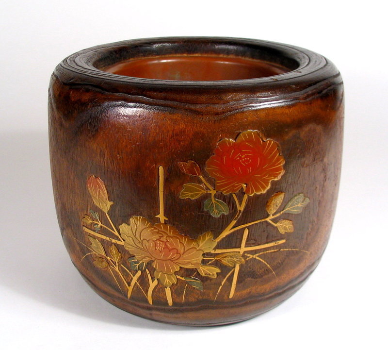 DESCRIPTION:  A handsome Japanese hibachi, crafted from a section of kiri wood (paulownia wood) with rounded body and lacquer floral designs.  Inside is the original copper liner where coals would be placed for heating or keeping a tea pot warm. Two large peony blossoms are lacquered in gold and orange on the front, with smaller leafed branches on the reverse.  Paulownia wood is very light, fine-grained, and warp-resistant, and is often used in Japan for chests and boxes.  Today Japanese hibachis are often used as decorative accents, attractive plant containers or for ikebana flower arrangements.   Dating from the Taisho to early Showa Period (appx. 1920 – 1940), and in good condition with light usage wear. DIMENSIONS: 7.25” high (18.5 cm) x 9” diameter (22.8 cm).    <div id='rater_target1303537'></div>
