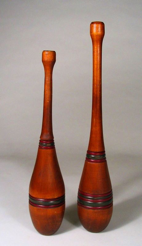 Pair<br /><br />
DESCRIPTION: Nice pair of wooden exercise clubs or juggling pins.  The bodies of both clubs have been turned and the lines painted in alternating colors of red and green. Very good condition with normal wear and no cracks.  DIMENSIONS: The taller club is 13.75” high; the shorter club is 12" high.  
<div id='rater_target1366869'></div>
