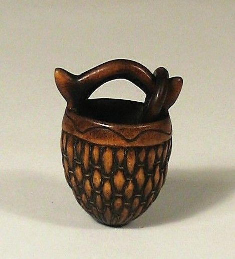 DESCRIPTION:  A fine Chinese boxwood water-well basket toggle, intricately carved in an acorn shape with a realistic and detailed basket weave pattern with carved wood rim. The arched overhead handle has a free-carved wood ring attached; the interior is hollowed out. Excellent condition, a beautiful toggle, 19th C.  For a similar example see: Schuyler Cammann, Substance and Symbol in Chinese Toggles, #188, p.228. DIMENSIONS: 1-3/4” high.
<div id='rater_target1367680'></div>
