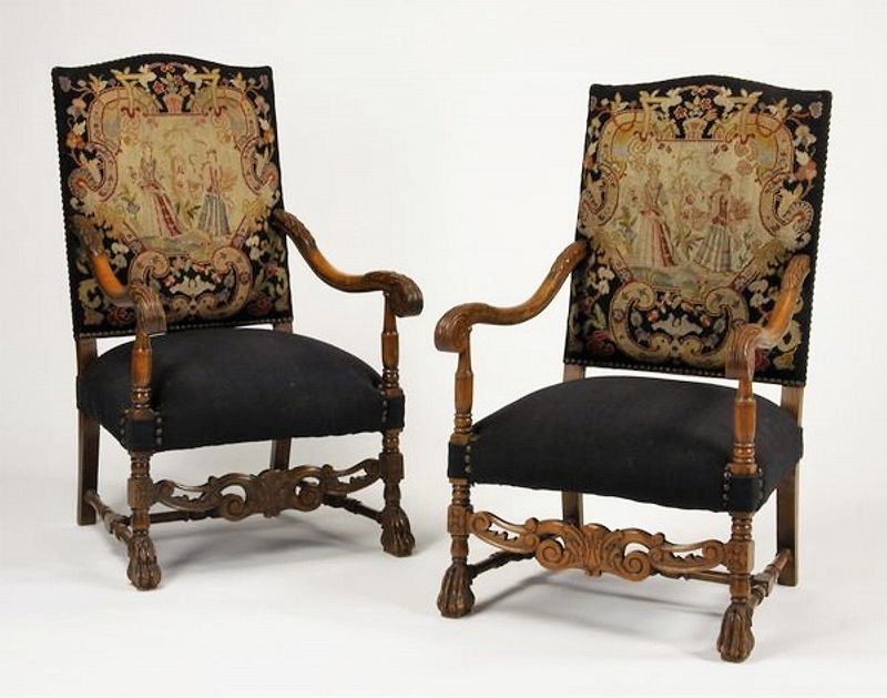 DESCRIPTION: A beautiful pair of late 19th century French carved walnut armchairs, with original gros point and petit point upholstery with nail head trim, the backrests with a central scrolling cartouche framing two maidens encircled with flowers. The seats and back are upholstered in dark blue/back fabric over a turned H-shaped stretcher base with a pierced, carved front stretcher, raised on animal paw feet. Very good condition, and the perfect complement to an Old World decor.  DIMENSIONS: 44"h x 26.5"w x 30.5"d.
<div id='rater_target1369807'></div>

