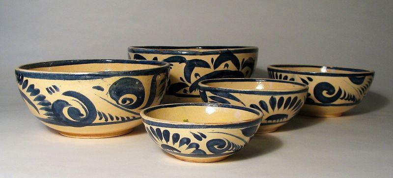 DESCRIPTION:  A lovely set of five red clay Mexican earthenware nesting bowls, dating from the 1950's.  The bowls are decorated in fluid strokes of blue between blue line borders on a white/cream ground.   The interiors have a line of blue around the inner circumference with dollops of green glaze.  Very good condition, no chips, original imperfections that add to the charm.  DIMENSIONS:  Largest bowl:  10.25 diameter x 4.75” high.  Smallest bowl: 5.5” diameter x 2” high.
<div id='rater_target1371927'></div>
