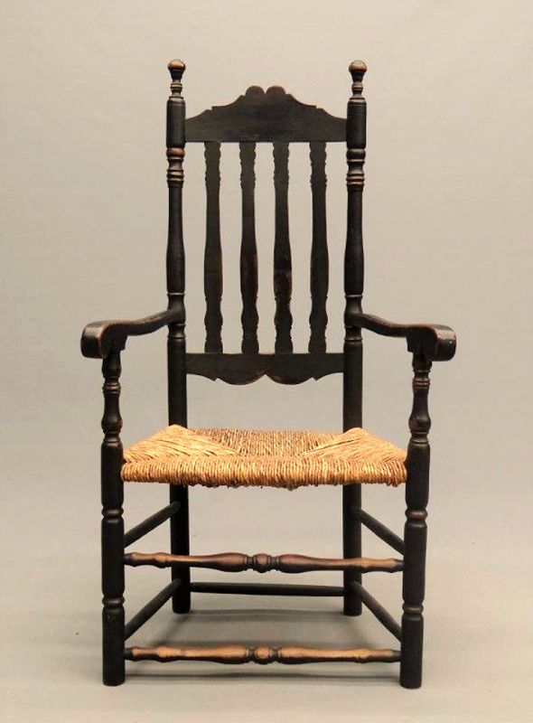 DESCRIPTION: An 18th c. banister back armchair having scalloped crest and bottom rails, turned finials, bulbous front spindles and rush seat. Good condition with age appropriate wear, original black paint. See our listing #A-CH3 for a near match companion chair to make a pair. DIMENSIONS: 46.5" high x 25” wide x 18.25 deep; 17" seat height. 
<div id='rater_target1373630'></div>
