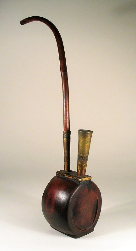 DESCRIPTION: A Qing dynasty bamboo pipe, possibly used for either opium or tobacco, with a bulbous body crafted from a large segment of giant bamboo. Mounted onto this segment are heavy brass fittings, one for the tubular tobacco bowl with its long brass shaft descending into the body. The other brass tube holds the long, bent bamboo stem that is used to draw the smoke out. Very good condition with a nice patina. DIMENSIONS: 16” high assembled (40.5 cm). The bamboo body is 3 ¾” wide (9.5 cm) x 3” deep (7.5 cm).   

MS63    $295
<div id='rater_target1383067'></div>
