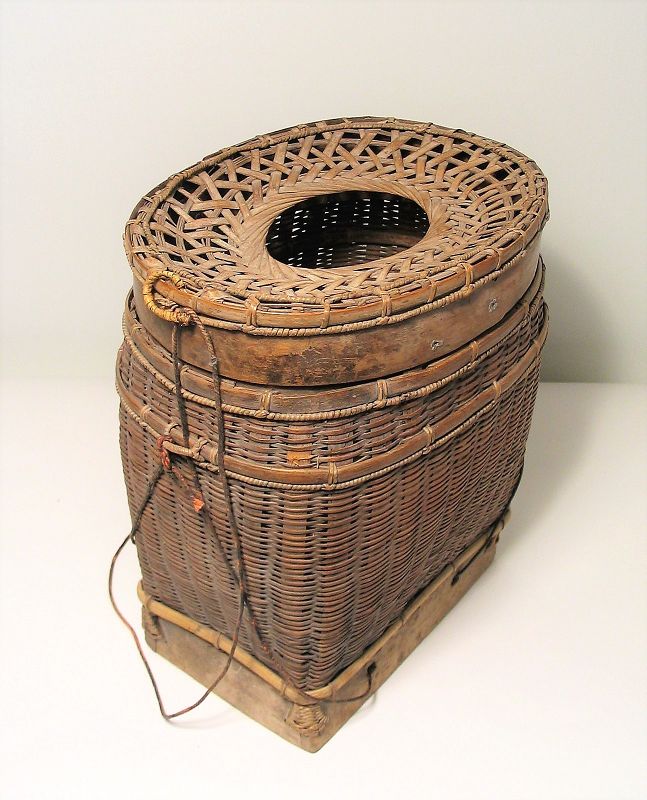 DESCRIPTION:  An attractive Asian fishing creel, fashioned from woven split bamboo with wood base and neck, and an attached tightly woven string for hanging.  A creel is used for carrying fish or blocks of peat moss which function as an evaporative cooler when dipped into a creek, keeping the catch chilled.  This type of creel with a woven, partially open top can also be used to catch lobsters and other crustaceans.  Good condition with a nice aged patina. DIMENSIONS:  9” wide x 11” high x 6 ½” deep.
<div id='rater_target1387214'></div>
