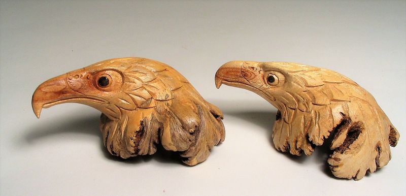 Pair<br /><br />
DESCRIPTION:  Two well carved burl eagle heads with fierce, proud eyes, hooked beaks and puffed, feathered necks. On the reverse of each you can see the highly intricate structure of the burl wood from which they were taken. This folk art artisan carver captured the majesty and essence of the USA’s national symbol, the Bald Eagle. The wood is from the Chinaberry tree which is native to Southern Asia, Australia and Oceania; however the tree was introduced to the American Southwest and Mexico by the Spanish settlers centuries ago where it flourished.  The tree, of the Mahogany family, offered welcome shade in the sundrenched southwest, wood that was easily worked, and seeds that were used for rosary beads.  Both carvings are in excellent condition, 20th C. DIMENSIONS: 4'' long x 2'' high x 3'' wide.
<div id='rater_target1389902'></div>
