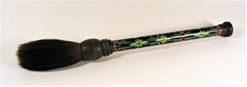 DESCRIPTION: An attractive scholar’s brush, the cloisonné handle having colorful vine and floral designs on a black ground. The ferrule and tip are both crafted from turned wood while natural bristles form the full brush. In excellent condition, this is a handsome, well made brush dating from the early 20th C. DIMENSIONS: 13.5" long (34.2 cm). 
<div id='rater_target1398210'></div>
