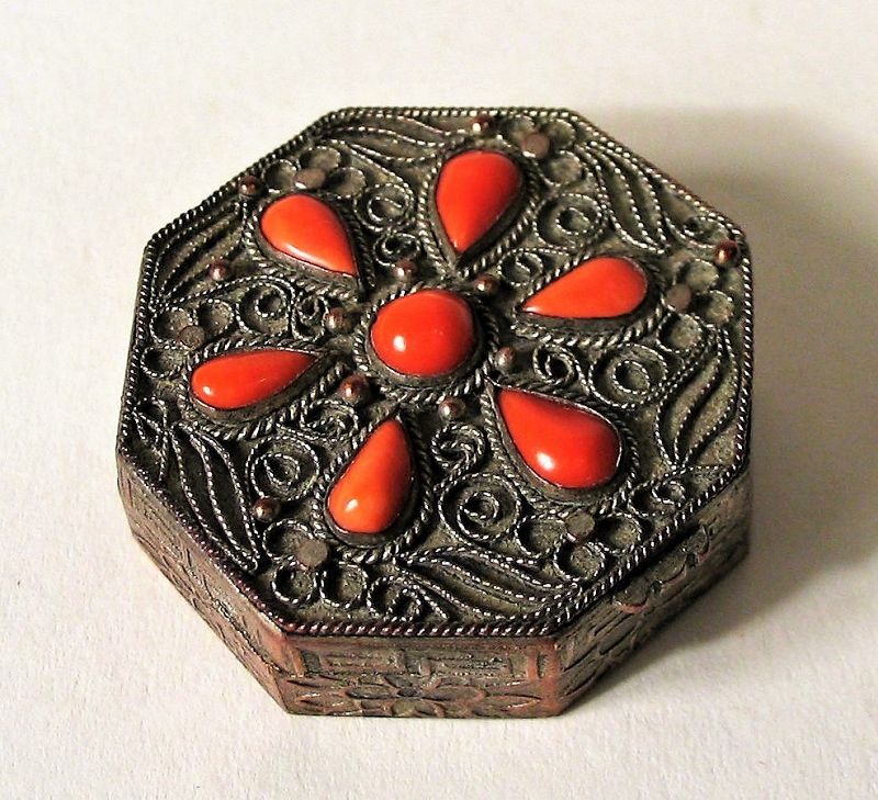 DESCRIPTION: A beautiful octagonal pill (or snuff) box, the top with silver filigree wire work around inset coal stones forming the shape of a five-petal flower. The box itself is silver over copper and on the inside is stamped “Made in China.” Amazingly, the original Frost Bros. retail tag remains on the inside. Frost Brothers was a high-fashion retail store based in San Antonio, Texas, that opened in 1917 and went out of business in 1988. This box dates from C. 1920 to 1945 (Republic Period), and is in very good condition with minor wear; hinge and clasp work perfectly. DIMENSIONS: 1 ¼” diameter.   

JO58  $170.00
<div id='rater_target1399059'></div>
